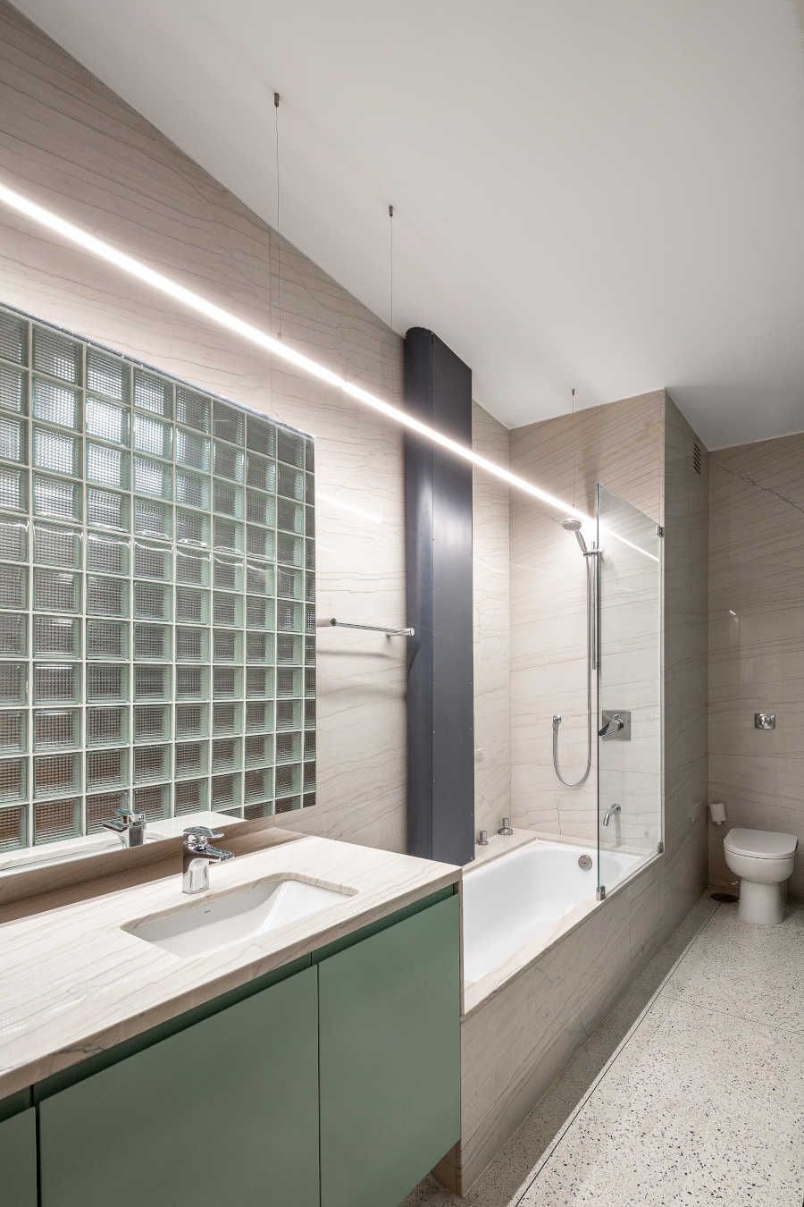 Banheiro com cores claras e blocos de vidro