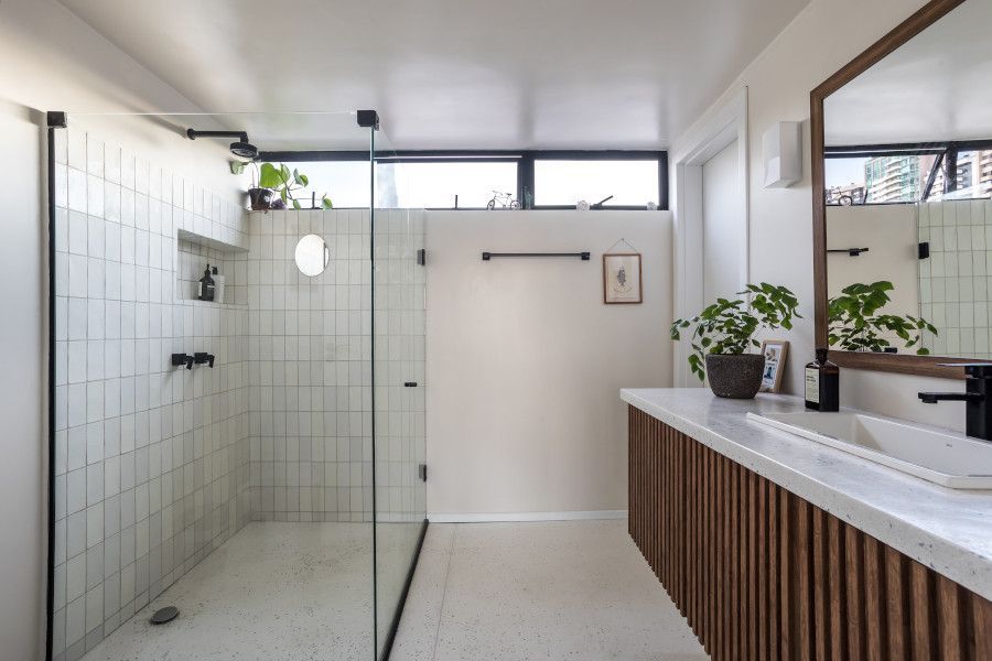Banheiro branco com marcenaria de madeira