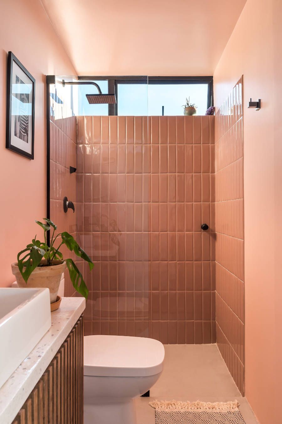 Banheiro rosa revestido com azulejos e tinta